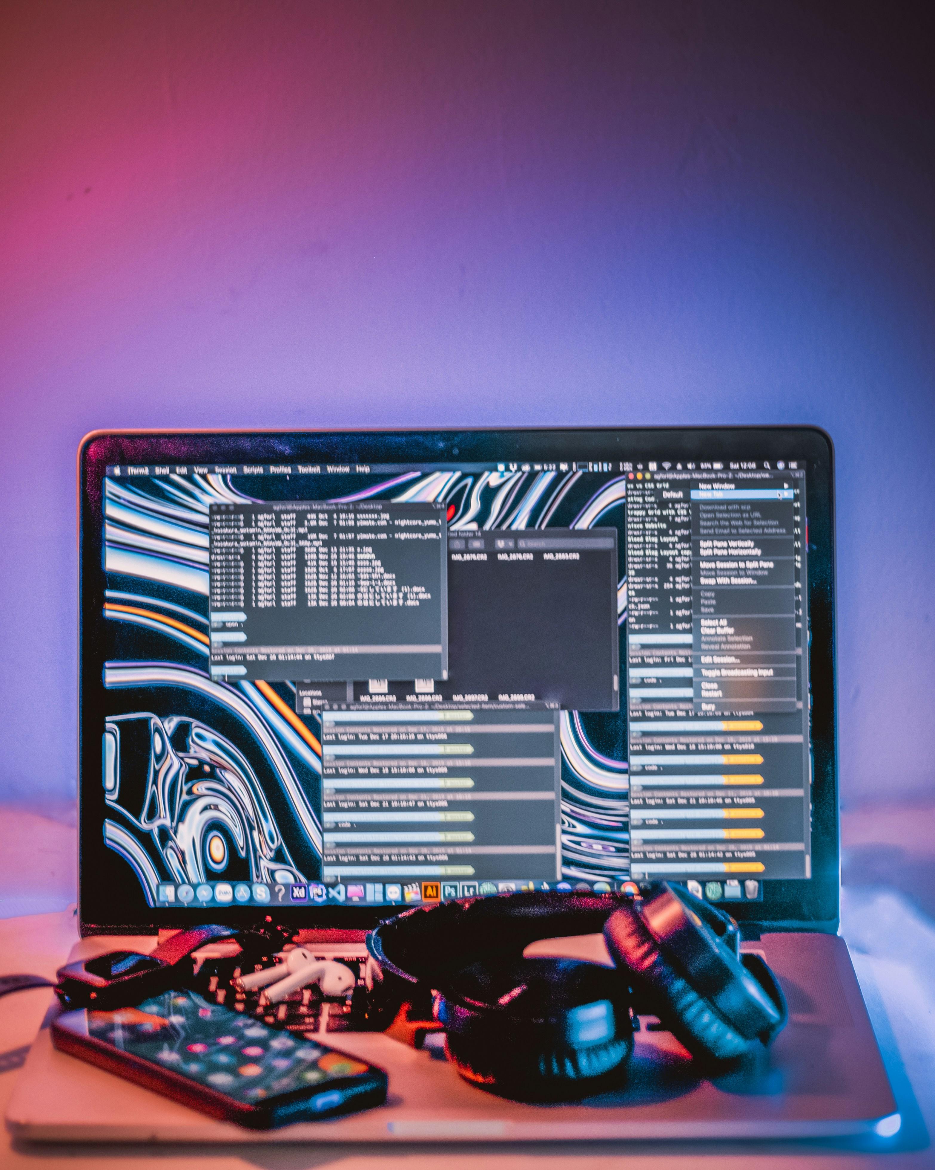 Open macbook with tech devices placed on keyboard